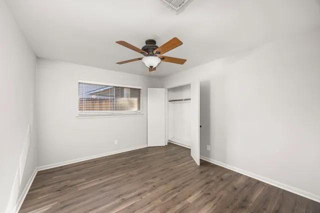 a view of a big room with wooden floor and a ceiling fan