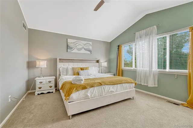 a bedroom with a bed and large windows