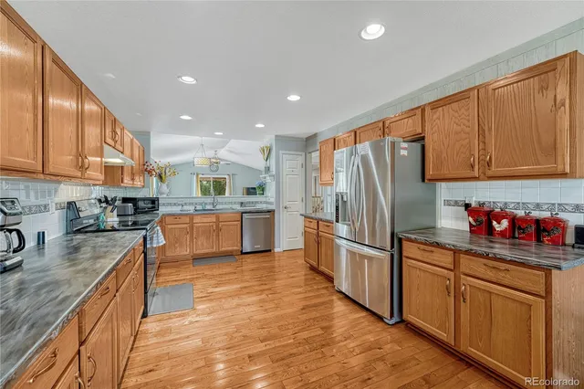a kitchen with stainless steel appliances granite countertop a refrigerator sink and cabinets
