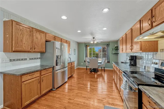 a large kitchen with stainless steel appliances granite countertop a lot of counter space and wooden floors
