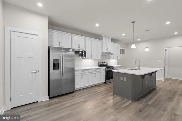 a kitchen with kitchen island a sink stainless steel appliances and cabinets