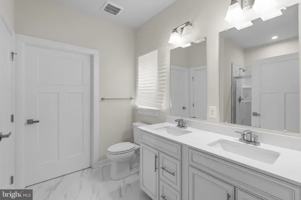 a bathroom with a sink a toilet and a large mirror