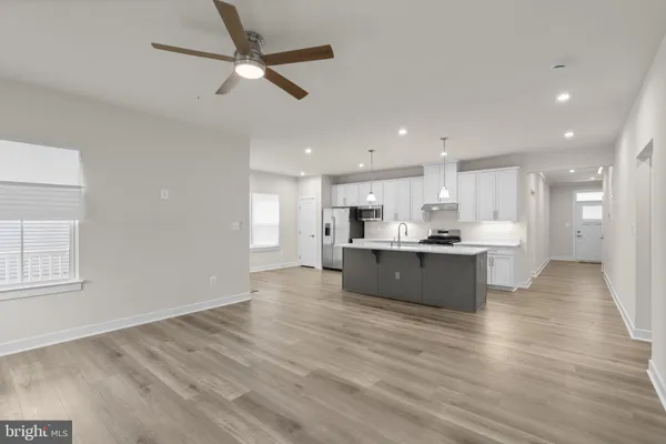 a large kitchen with stainless steel appliances granite countertop a large counter top and wooden floors