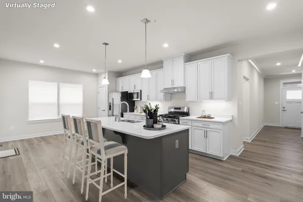 a kitchen with stainless steel appliances kitchen island granite countertop a sink a stove a dining table and chairs