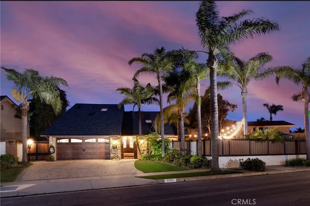a view of a house with a yard and potted plants