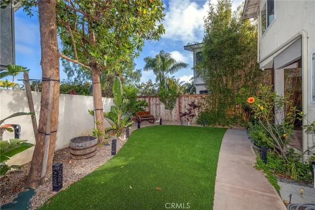 a view of a patio with table and chairs potted plants and large tree