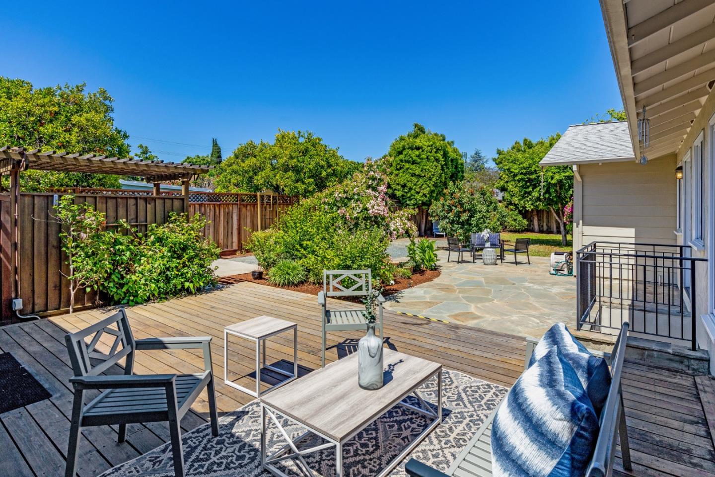576 Bush Street Mountain View, CA 94041 - Photo 1 of 21 a view of a patio with table and chairs and potted plants with wooden floor and fence