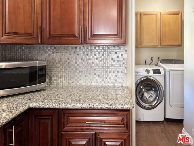 a kitchen with granite countertop cabinets and washing machine