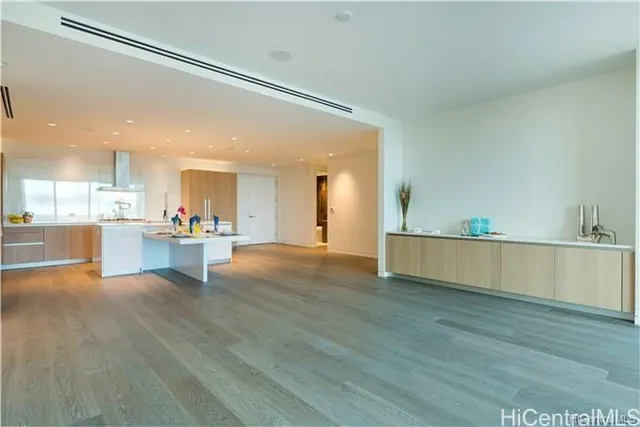 a view of a kitchen with kitchen island a sink wooden floor and a large window