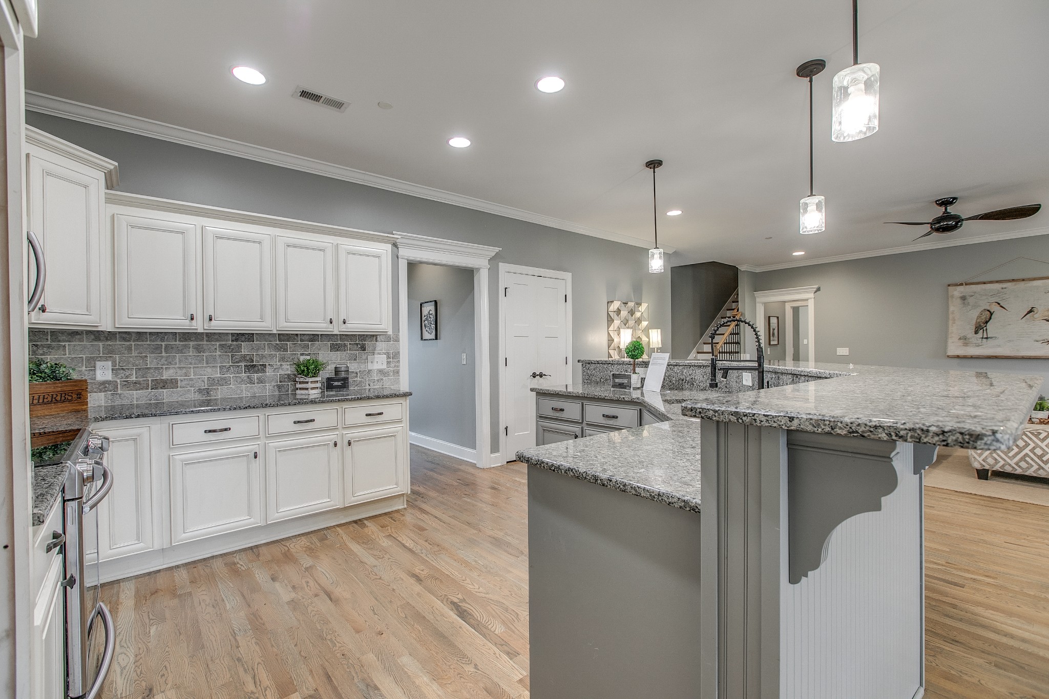 1102 Cascadeway Drive Murfreesboro, TN 37129 - Photo 15 of 45 a kitchen with granite countertop a stove a sink a refrigerator and white cabinets with wooden floor