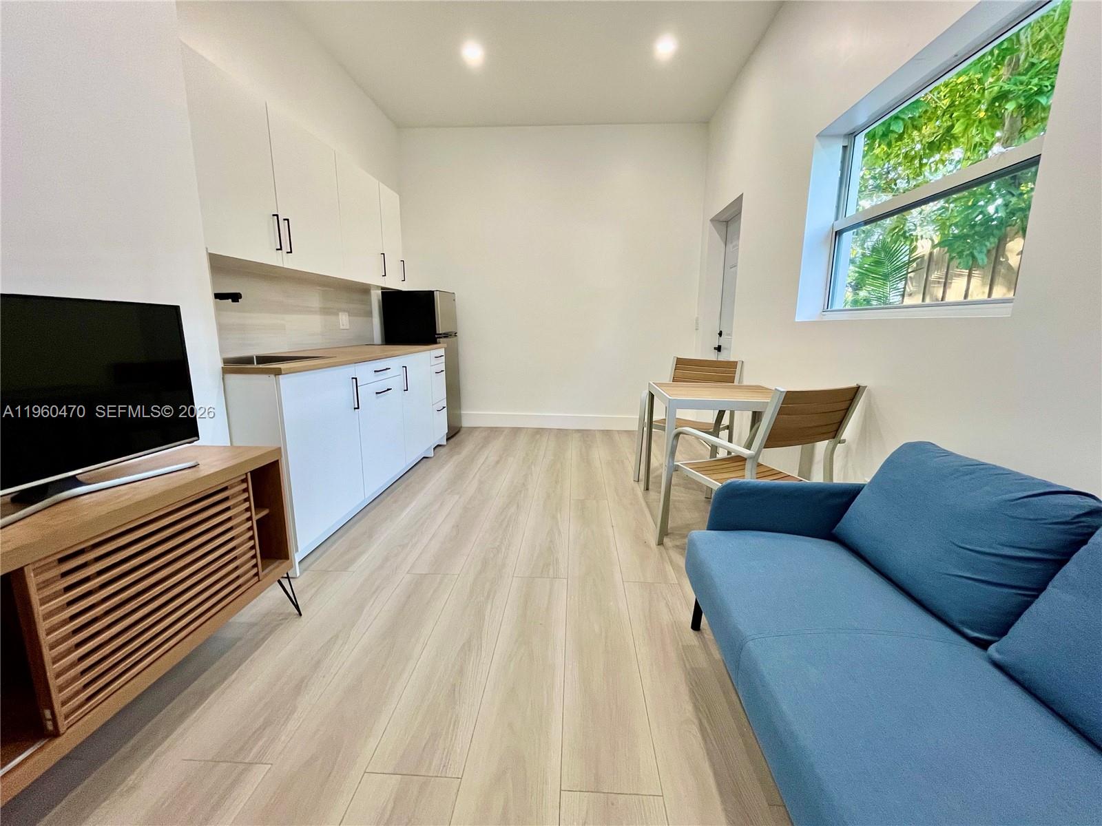 6241 Northwest Miami Place Miami, FL 33150 - Photo 12 of 33 a living room with furniture and a flat screen tv