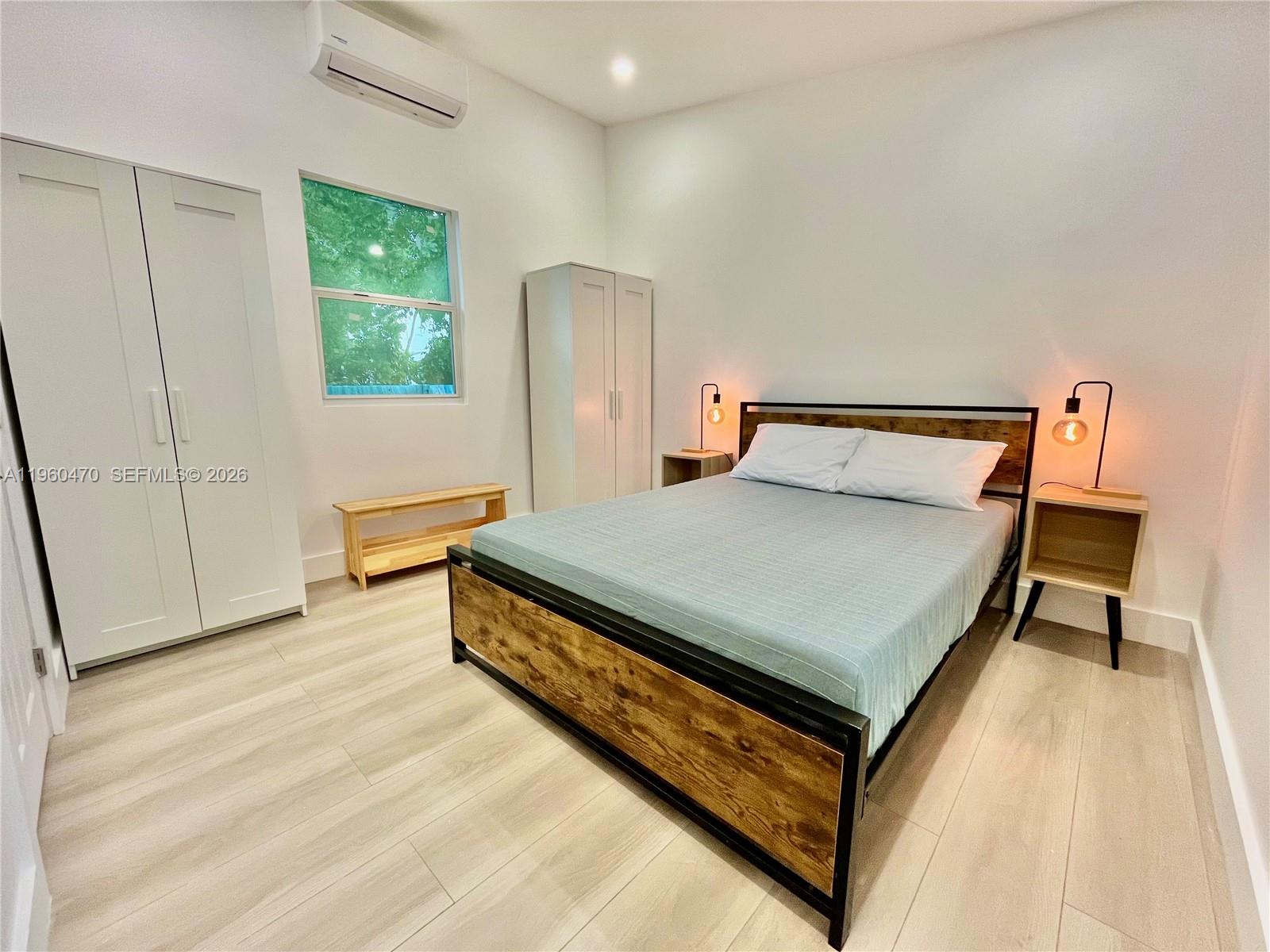 6241 Northwest Miami Place Miami, FL 33150 - Photo 16 of 33 a bed sitting in a bedroom next to a window