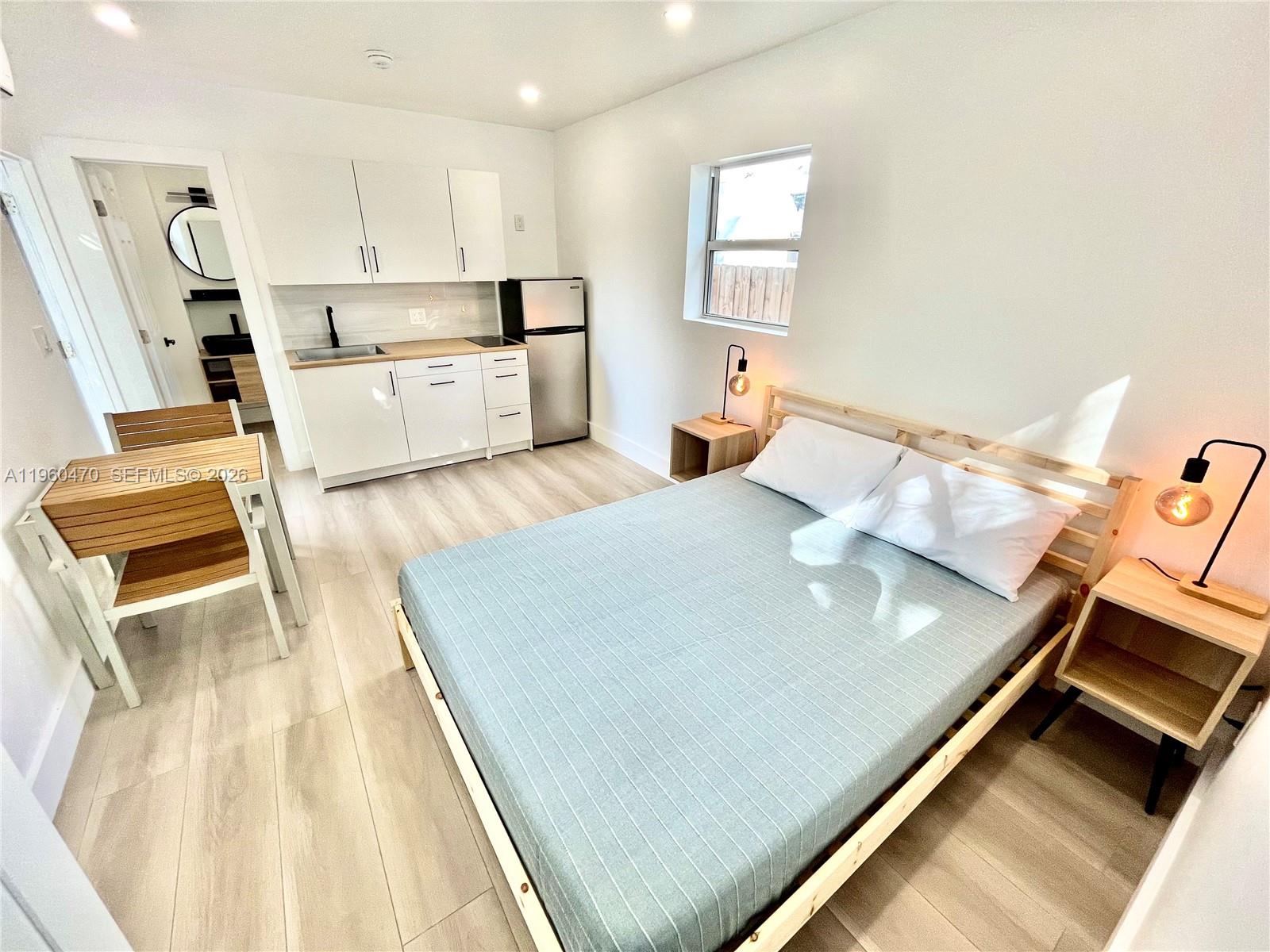 6241 Northwest Miami Place Miami, FL 33150 - Photo 23 of 33 a living room with a bed furniture and a wooden floor