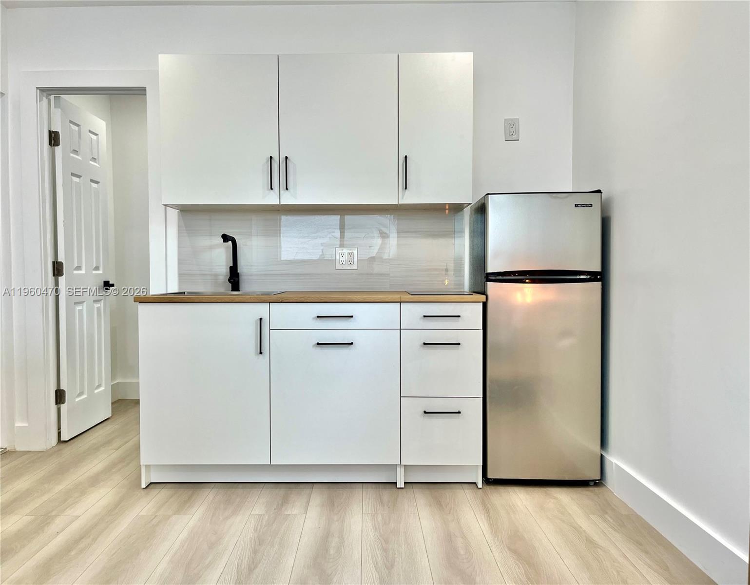 6241 Northwest Miami Place Miami, FL 33150 - Photo 29 of 33 a kitchen with cabinets and stainless steel appliances