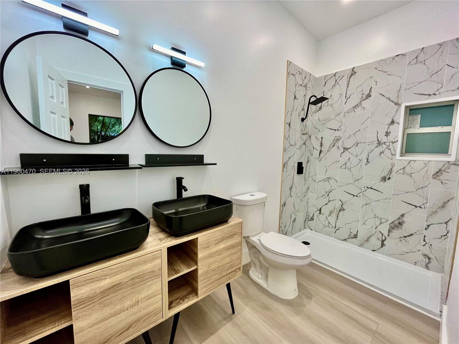 6241 Northwest Miami Place Miami, FL 33150 - Photo 4 of 33 a bathroom with a toilet a sink and a mirror