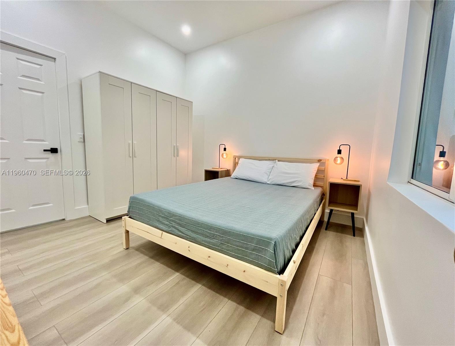 6241 Northwest Miami Place Miami, FL 33150 - Photo 8 of 33 a bedroom with a bed and a window