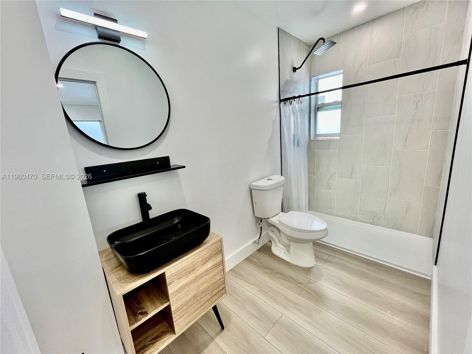 6241 Northwest Miami Place Miami, FL 33150 - Photo 10 of 33 a bathroom with a toilet a sink and a mirror