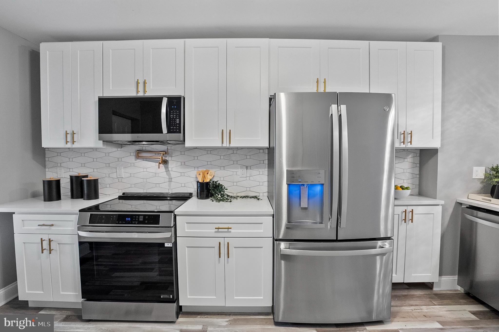 1201 North Fulton Avenue Baltimore, MD 21217 - Photo 15 of 36 a kitchen with white cabinets and stainless steel appliances