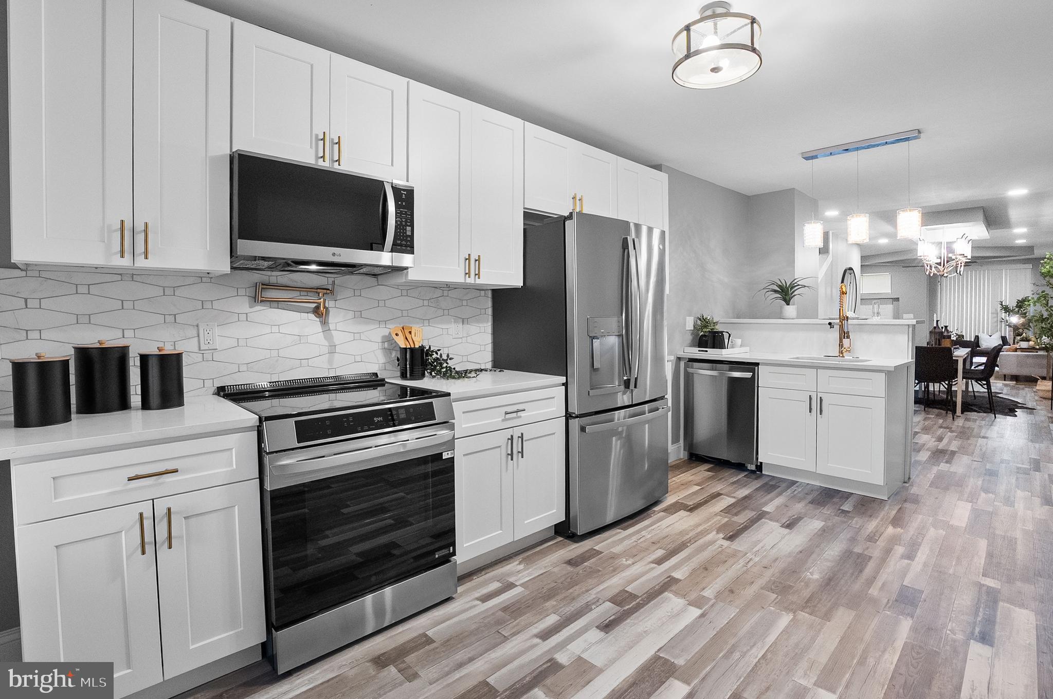 1201 North Fulton Avenue Baltimore, MD 21217 - Photo 4 of 36 a kitchen with a sink stainless steel appliances and white cabinets