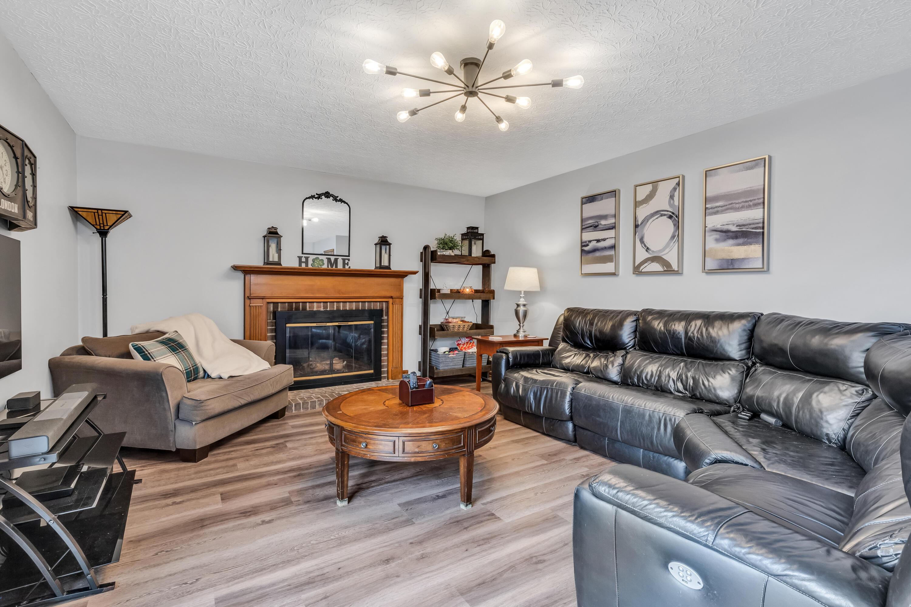 435 Emory Street Gahanna, OH 43230 - Photo 20 of 54 • New luxury vinyl plank
flooring ~ 2022
• Pale grey painted walls
• Woodburning brick fireplace
with mantle & raised
hearth
• Double sliding doors to
deck
• New ceiling light
• Drapes remain
