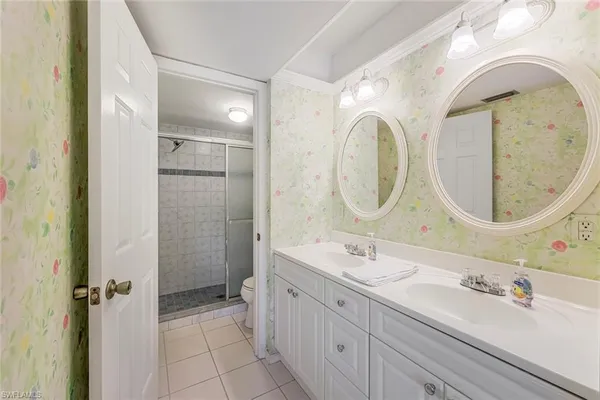 a spacious bathroom with a double vanity sink a mirror and a shower