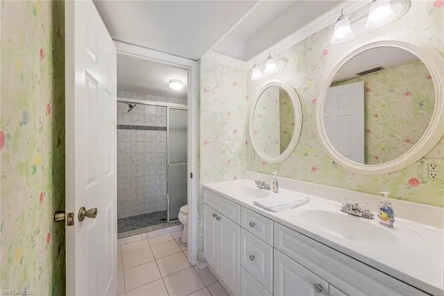 a spacious bathroom with a double vanity sink a mirror and a shower