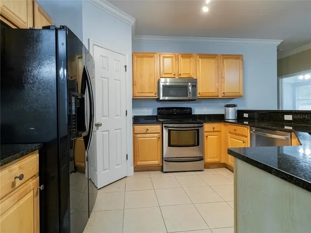 a kitchen with stainless steel appliances a stove refrigerator sink and microwave