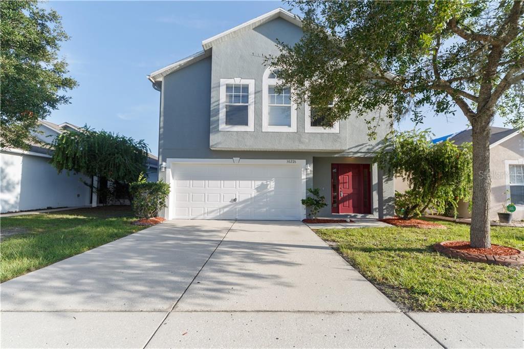 30226 Rattana Court Wesley Chapel, FL 33545 - Photo 1 of 1 a front view of a house with a yard and trees