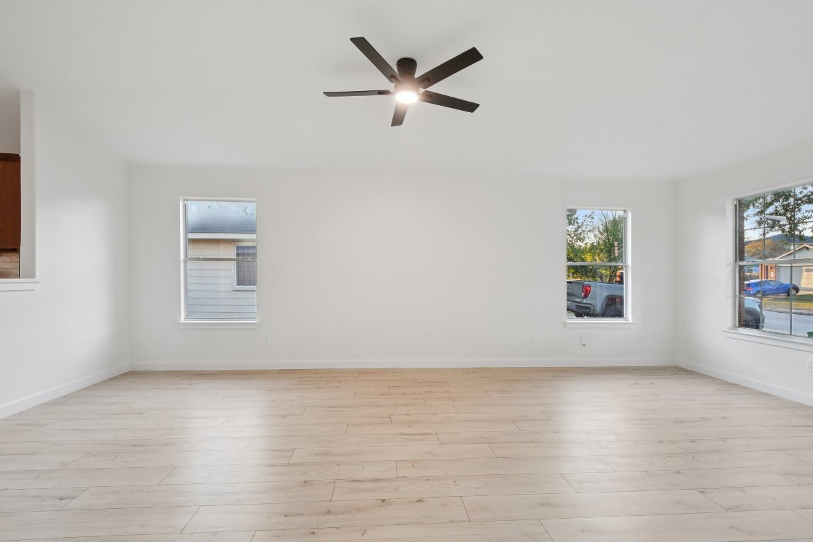 17921 Basket Flower Bend Elgin, TX 78621 - Photo 11 of 40 an empty room with wooden floor chandelier fan and windows