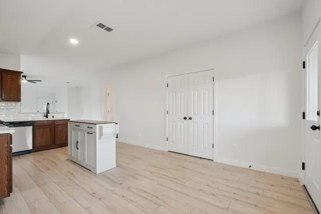 a view of a kitchen with wooden floor and electronic appliances