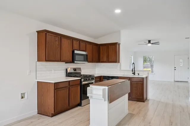 a kitchen with stainless steel appliances a sink stove and cabinets