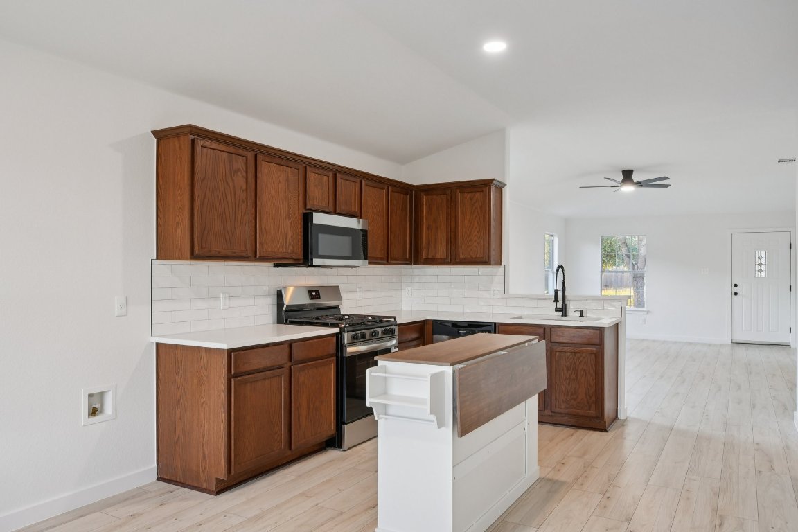 17921 Basket Flower Bend Elgin, TX 78621 - Photo 17 of 40 a kitchen with stainless steel appliances a sink stove and cabinets