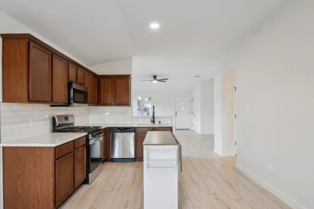 a kitchen with stainless steel appliances a sink stove and cabinets
