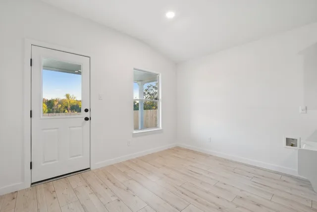 an empty room with wooden floor and a window
