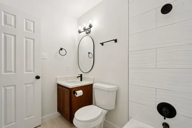 a bathroom with a toilet a sink and mirror