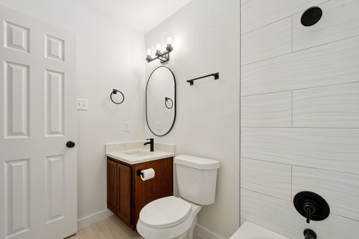 17921 Basket Flower Bend Elgin, TX 78621 - Photo 24 of 40 a bathroom with a toilet a sink and mirror