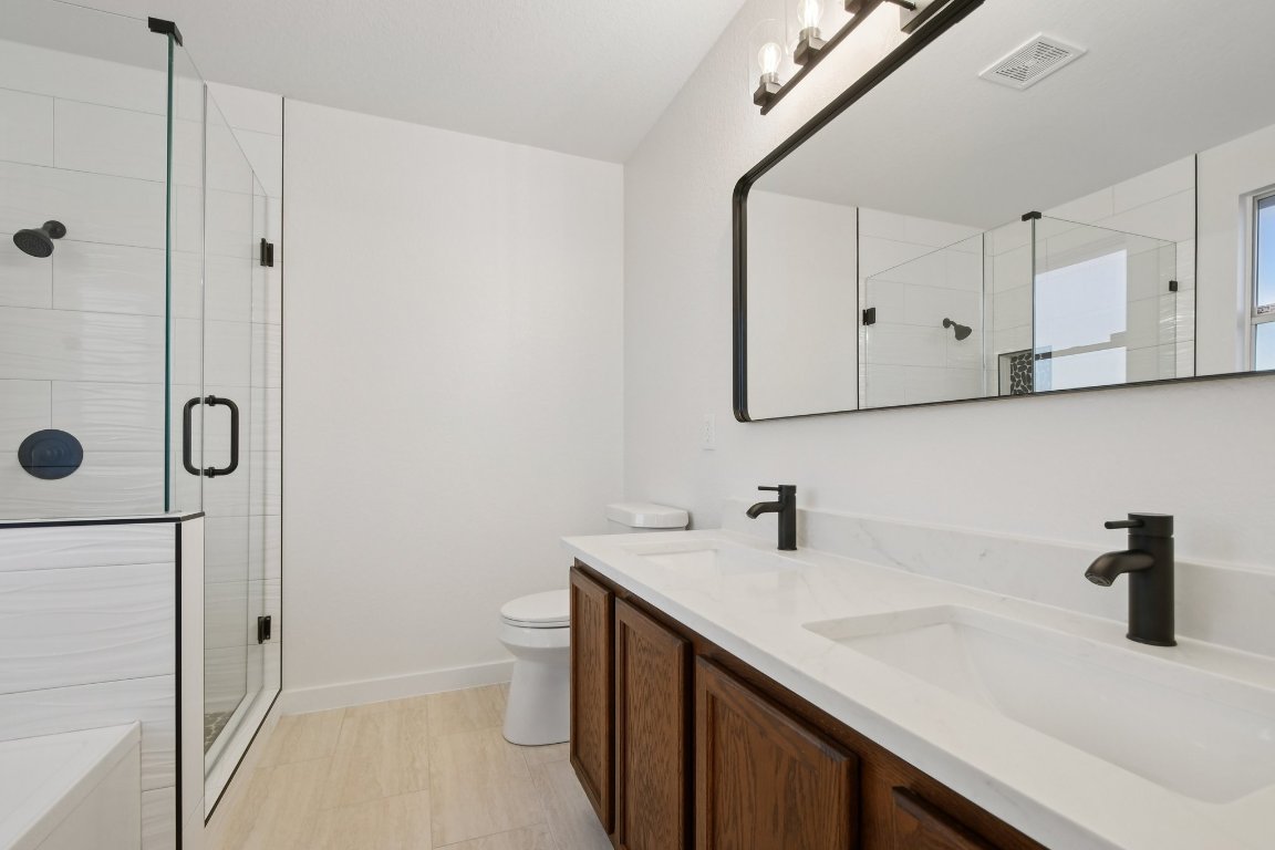 17921 Basket Flower Bend Elgin, TX 78621 - Photo 35 of 40 a bathroom with a sink a toilet and shower