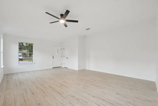a view of empty room with wooden floor