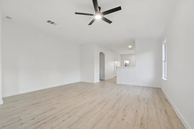 a view of empty room with wooden floor