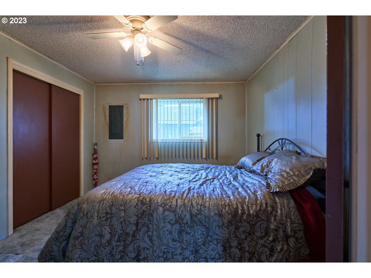 502 Southeast Evans Lane Enterprise, OR 97828 - Photo 13 of 18 a bedroom with a bed and a chandelier