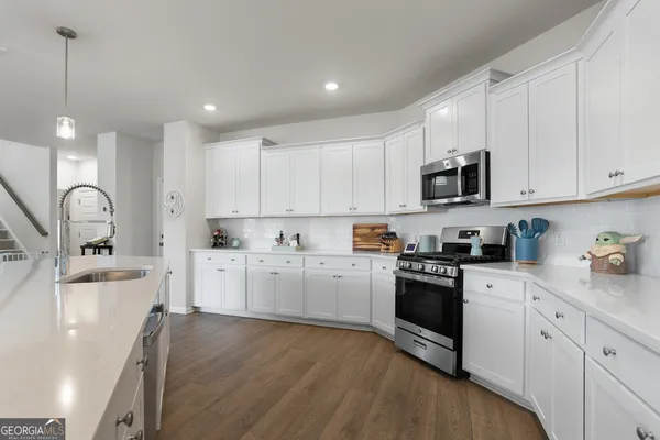 a kitchen with granite countertop white cabinets and white appliances