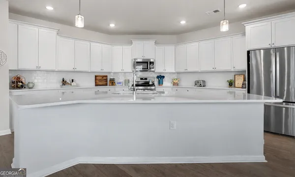 a kitchen with stainless steel appliances granite countertop a stove a white cabinets and a sink