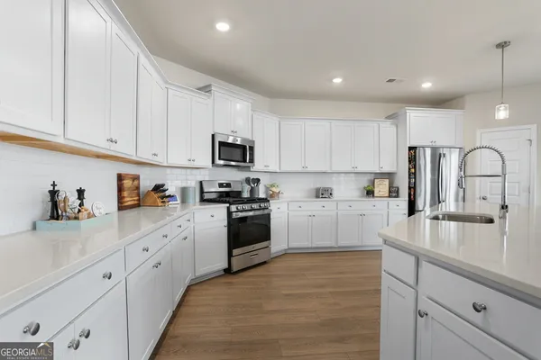 a kitchen with granite countertop white cabinets and white appliances