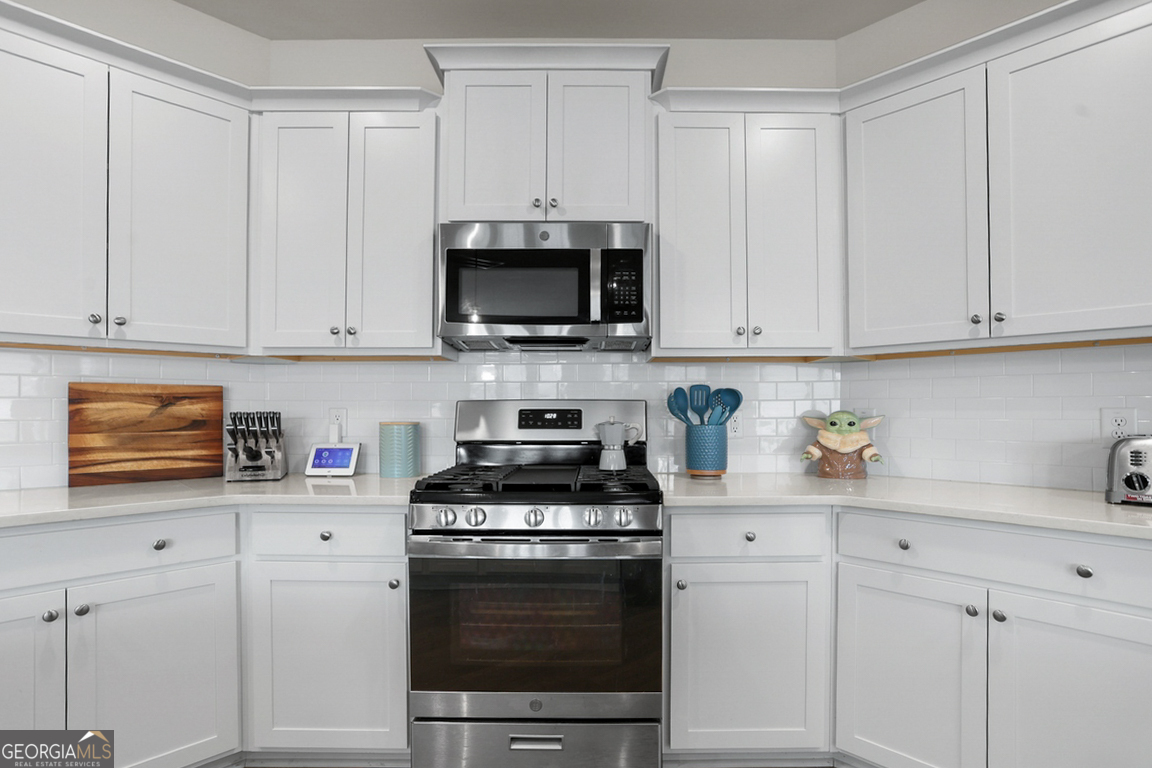 102 Franklins Walk Rincon, GA 31326 - Photo 21 of 51 a kitchen with stainless steel appliances granite countertop a stove a white cabinets and a sink