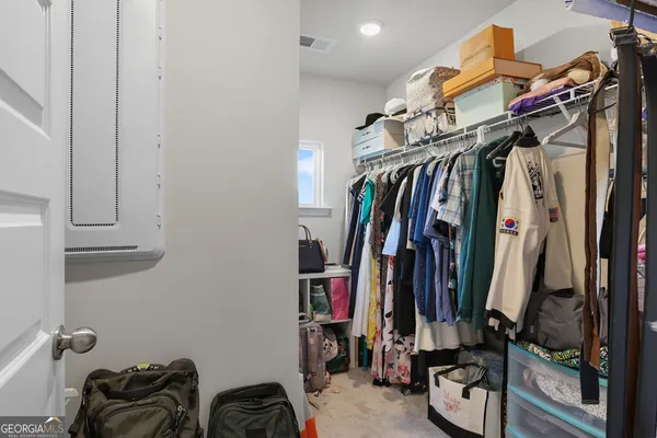 a view of walk in closet with clothes and shoes
