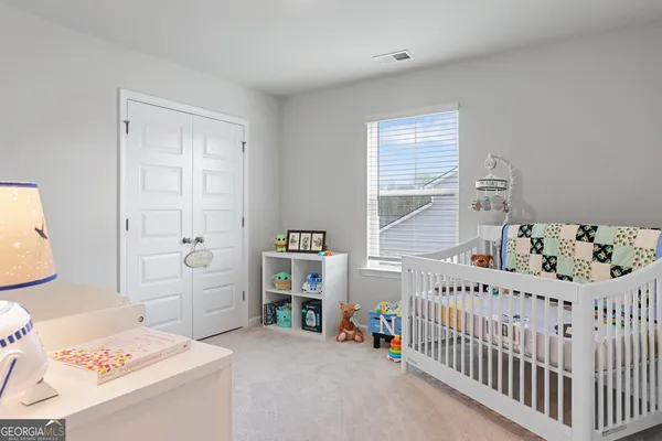 a room with a baby crib and a dresser