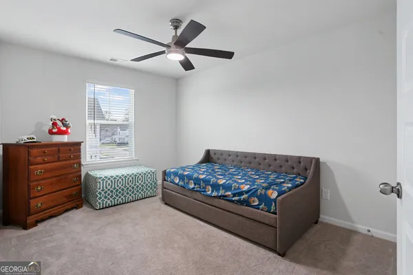 a bedroom with a bed and a ceiling fan