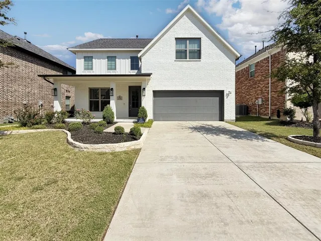 a front view of a house with garden and plants
