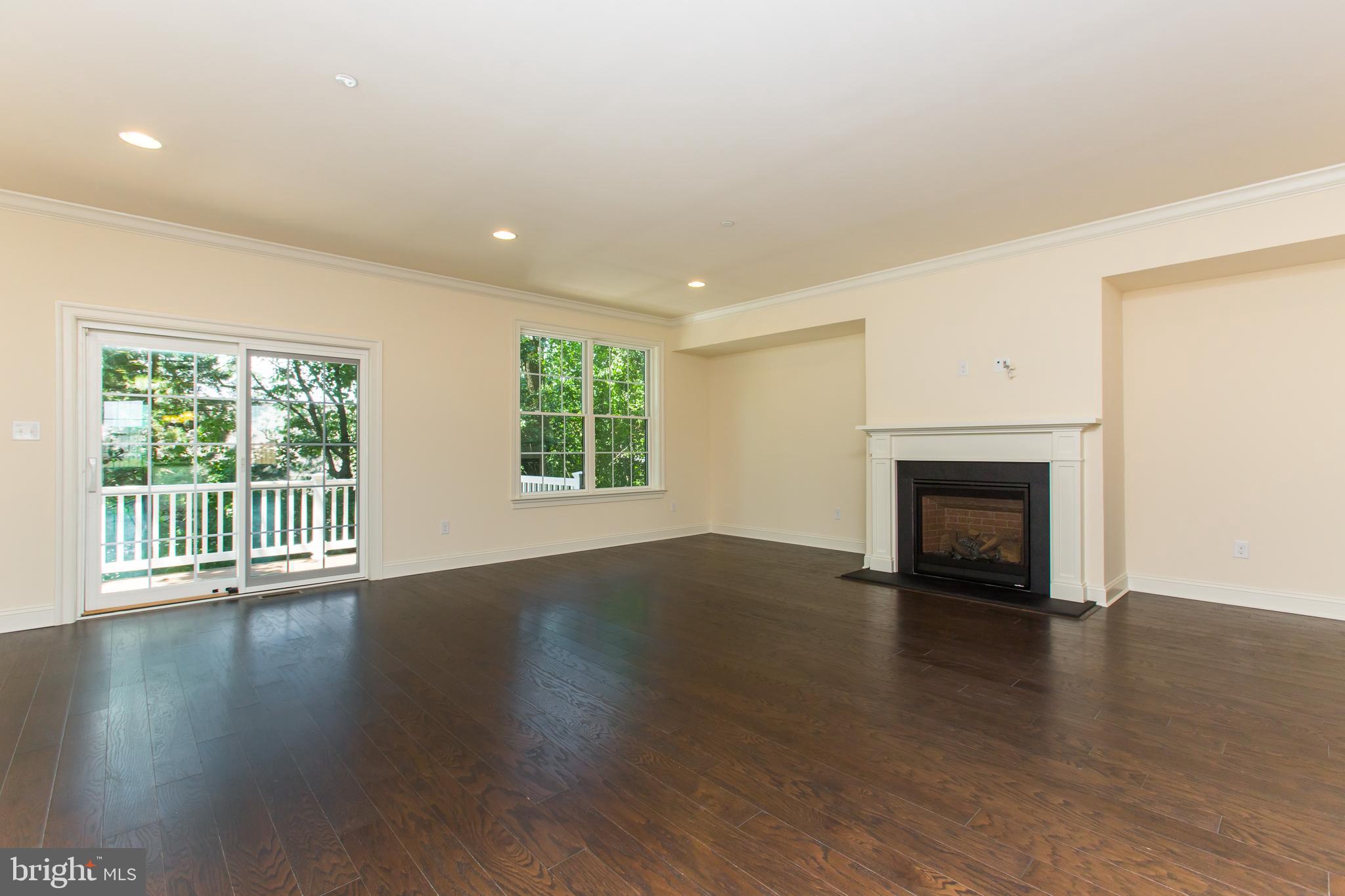 18 Parkview Cir. Wayne, PA 19087 - Photo 8 of 33 an empty room with wooden floor fireplace and windows