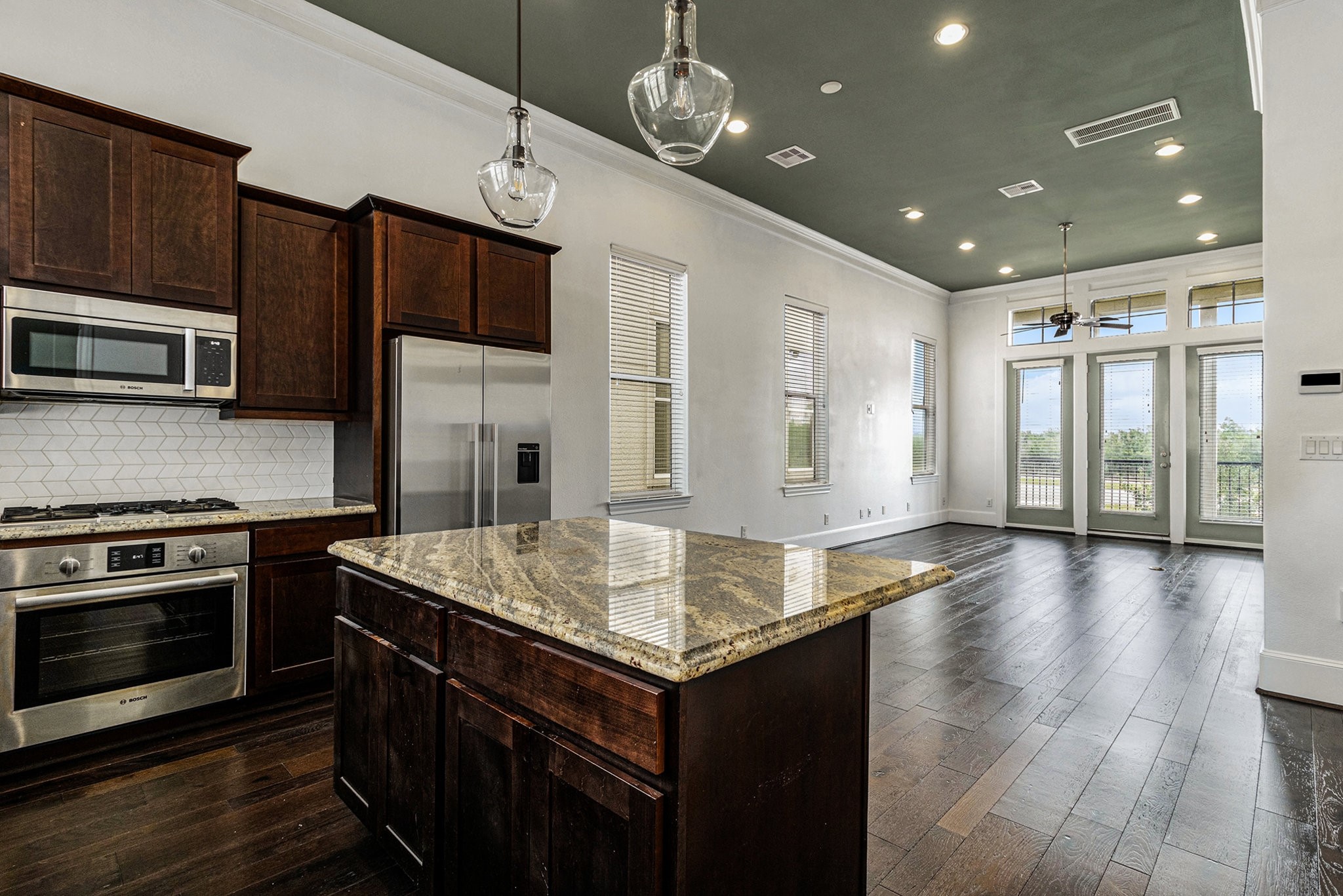 9674 Knight Road Houston, TX 77045 - Photo 11 of 21 a kitchen with kitchen island granite countertop wooden cabinets a stove and a oven